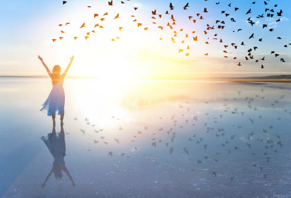 Woman on lake at sunset representing freedom